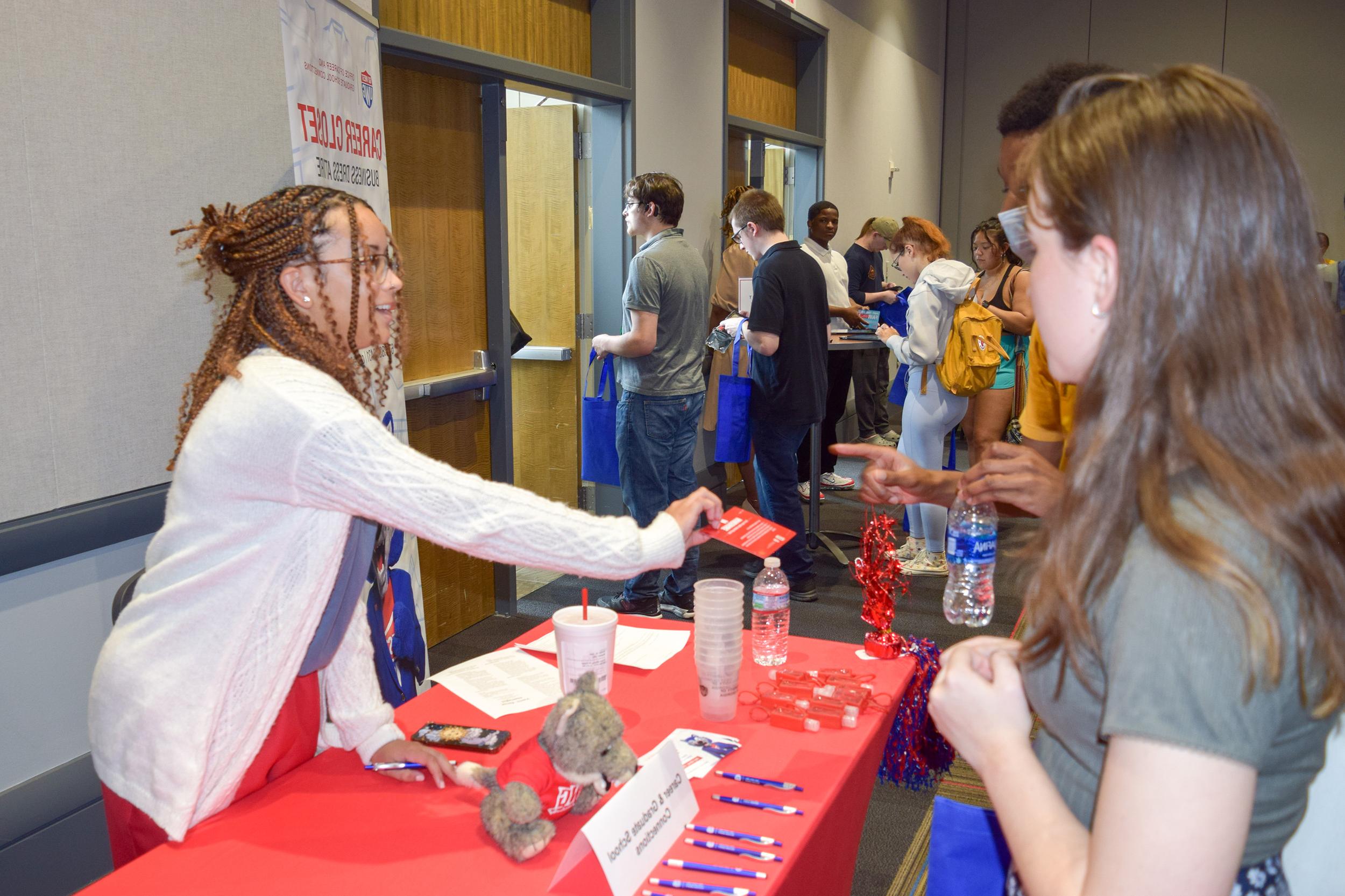 Careers office talking to students at a tabling event handing out information